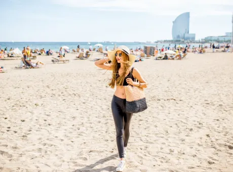 lifestyle portrait pretty woman with sunhat bag beach barcelona